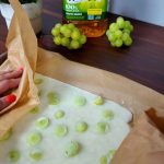 Uvas verdes congeladas sobre papel de hornear, un snack saludable y refrescante.